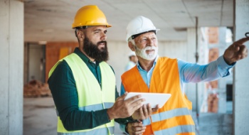 Construction workers discuss project plans at a busy worksite
