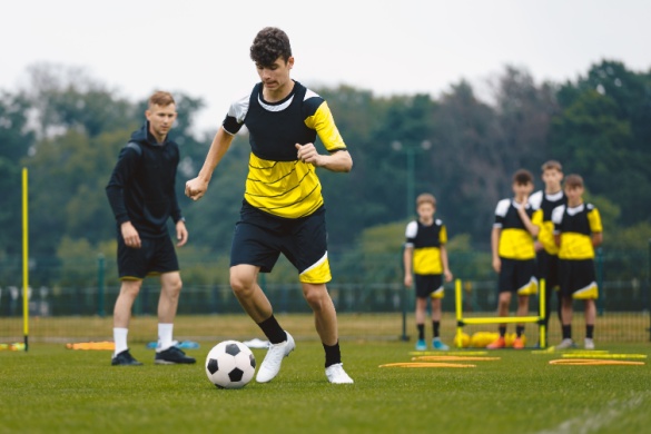 A men's soccer team practices drills on the field