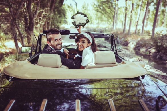 Two newlyweds make their grand exit in a vintage car 